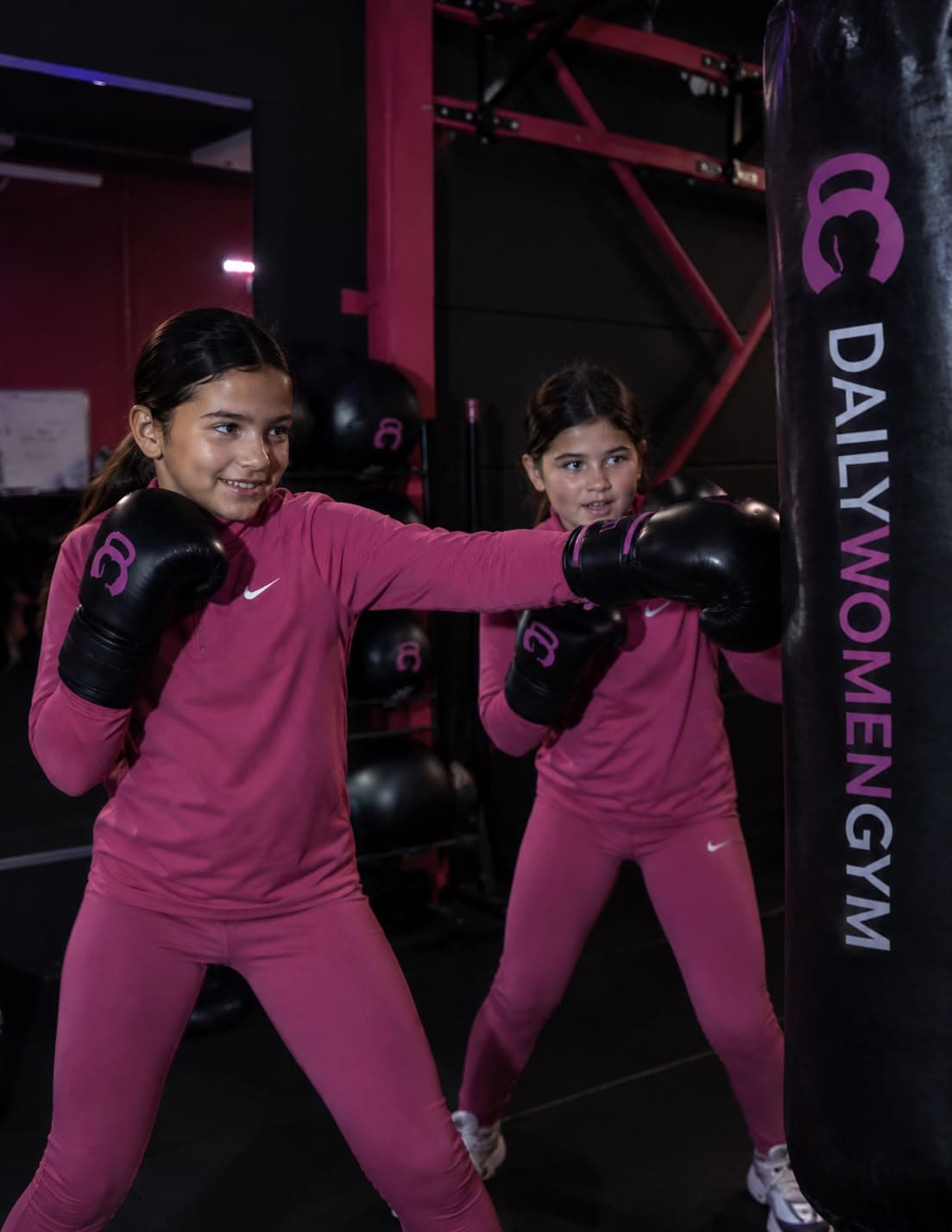 Twee jonge meiden kickboksen met bokshandschoenen bij Daily Women Gym